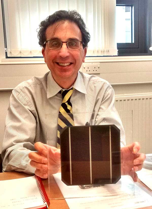 Photo of Oxford PV chief technology officer Chris Case holding a tandem silicon solar cell wafer featuring a perovskite coating.