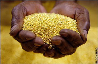 A worker holds gold granules at the Rand Refinery. Gold is now more precious than ever.